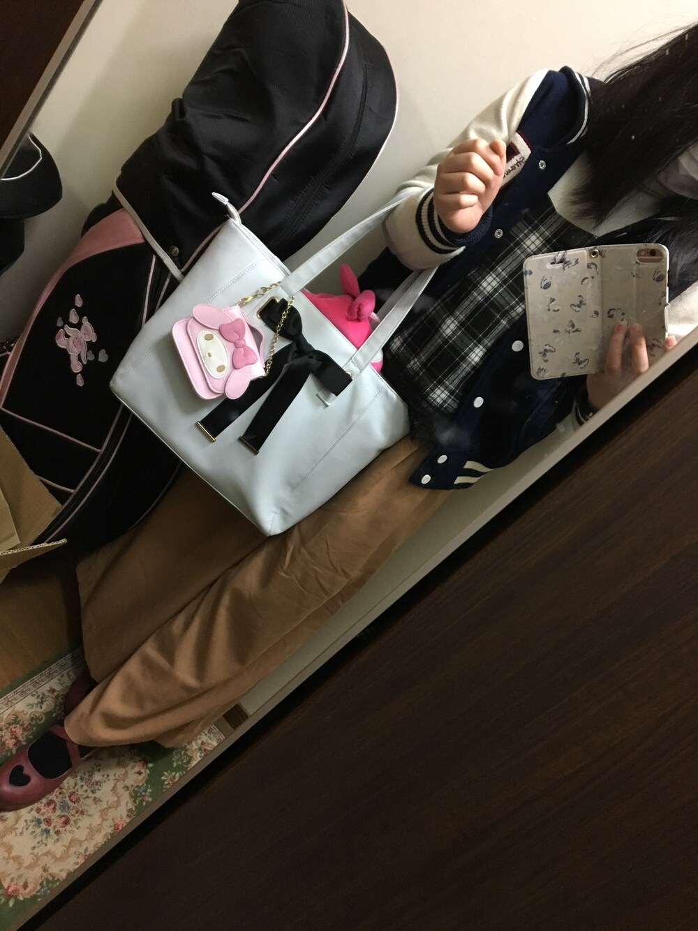 ブルー系のトートバッグ、ホワイト系のTシャツ/カットソー、ホワイト系のニット/セーターを着用したレディースの冬コーディネートの1枚目の写真