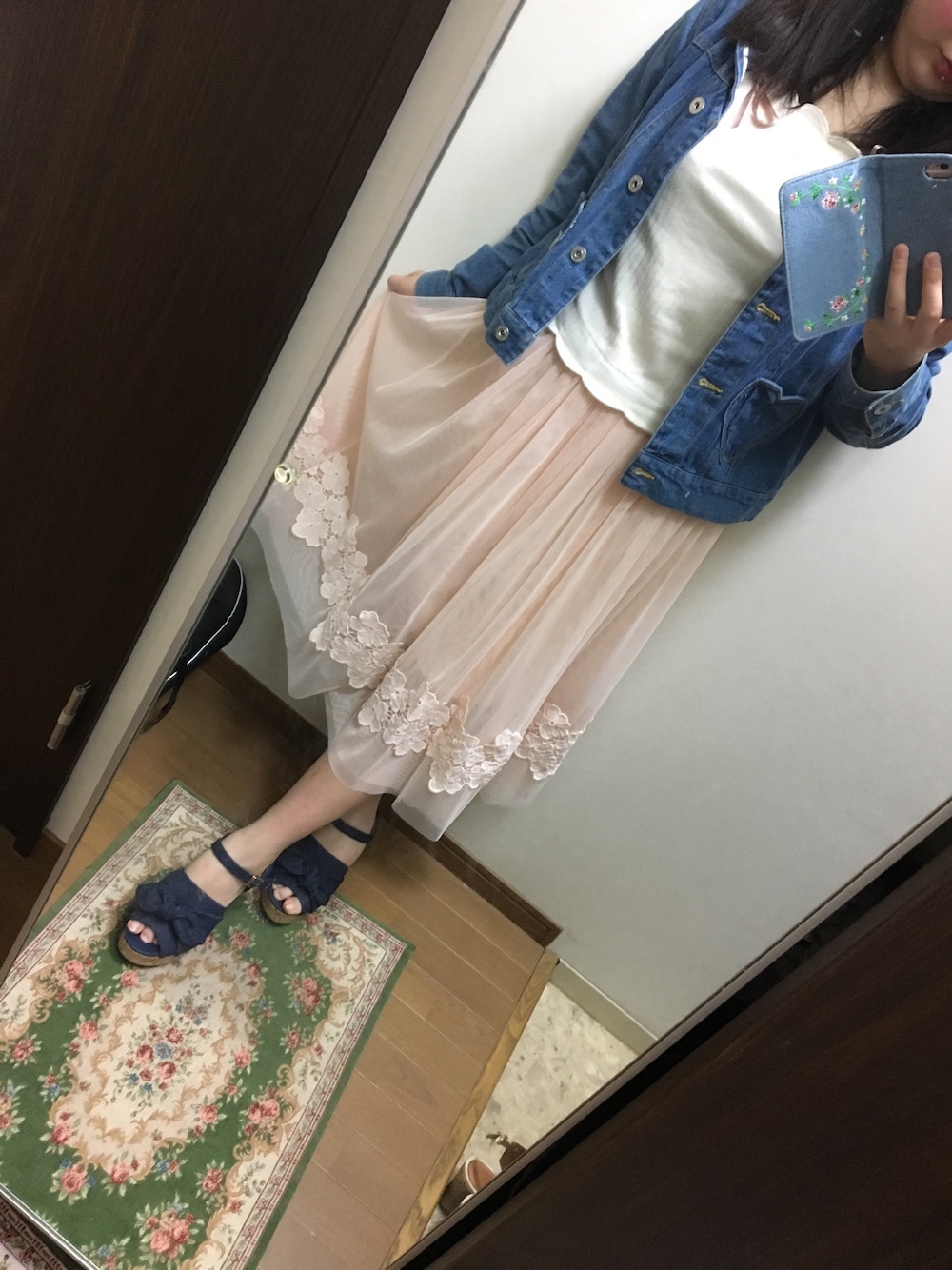 ピンク系のスカート、ホワイト系のトップス、ブルー系のデニムジャケットを着用したレディースの春コーディネートの1枚目の写真