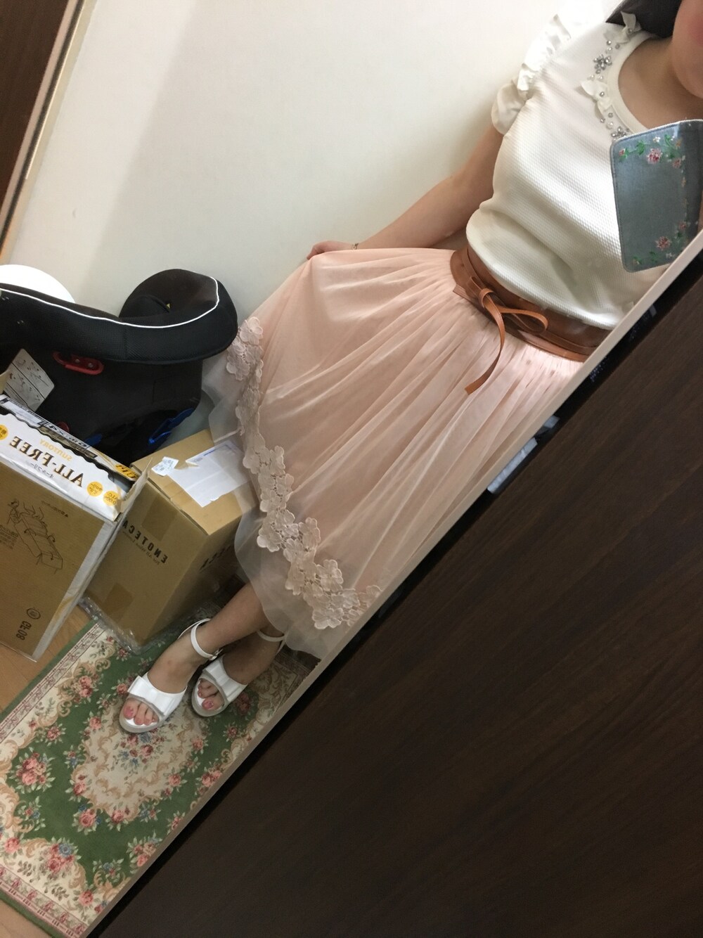 ピンク系のスカート、ホワイト系のトップス、ホワイト系のサンダルを着用したレディースの夏コーディネートの1枚目の写真