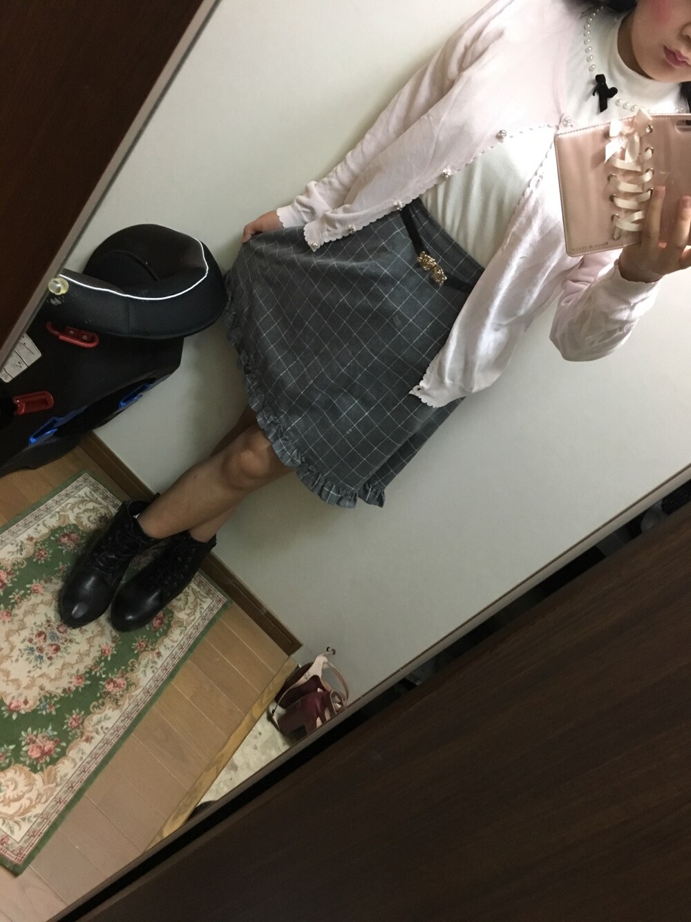 グレー系のスカート、ホワイト系のトップス、ピンク系のカーディガン/ボレロを着用したレディースの秋コーディネートの1枚目の写真