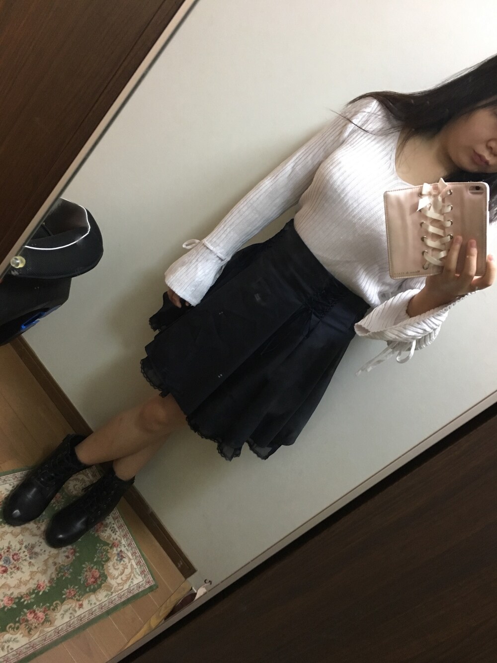 ブルー系のスカート、ピンク系のトップス、ブラック系のブーティを着用したレディースの秋コーディネートの1枚目の写真