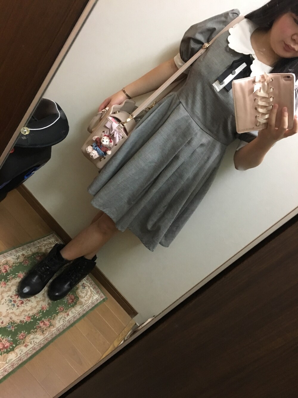 グレー系のワンピース、ピンク系のショルダーバッグ、ブラック系のブーティを着用したレディースの秋コーディネートの1枚目の写真