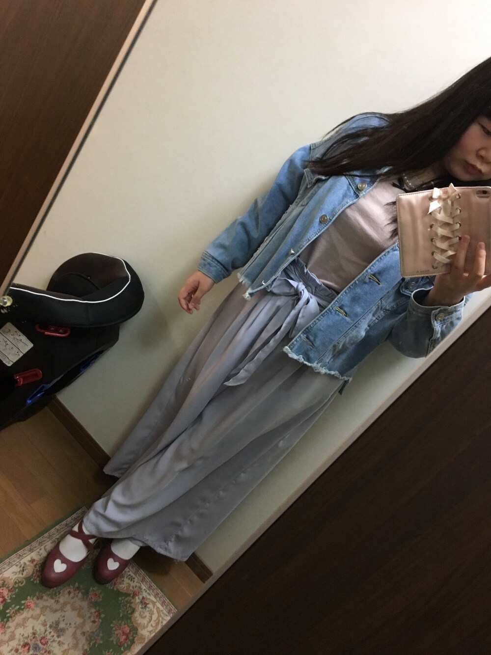 グレー系のパンツ、ピンク系のトップス、ブルー系のデニムジャケットを着用したレディースの秋コーディネートの1枚目の写真