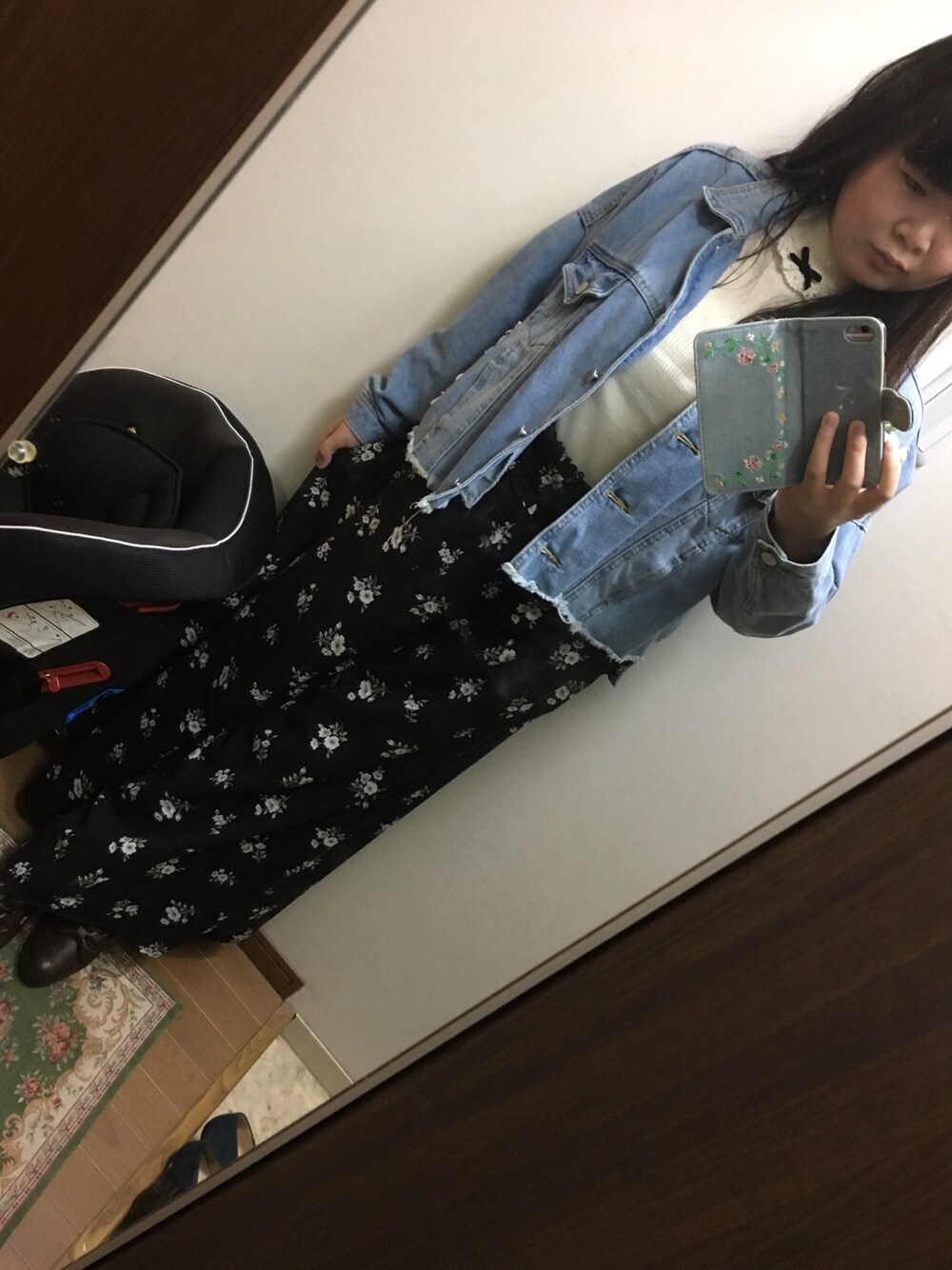 ブラック系のパンツ、ホワイト系のトップス、ブルー系のデニムジャケットを着用したレディースの秋コーディネートの1枚目の写真