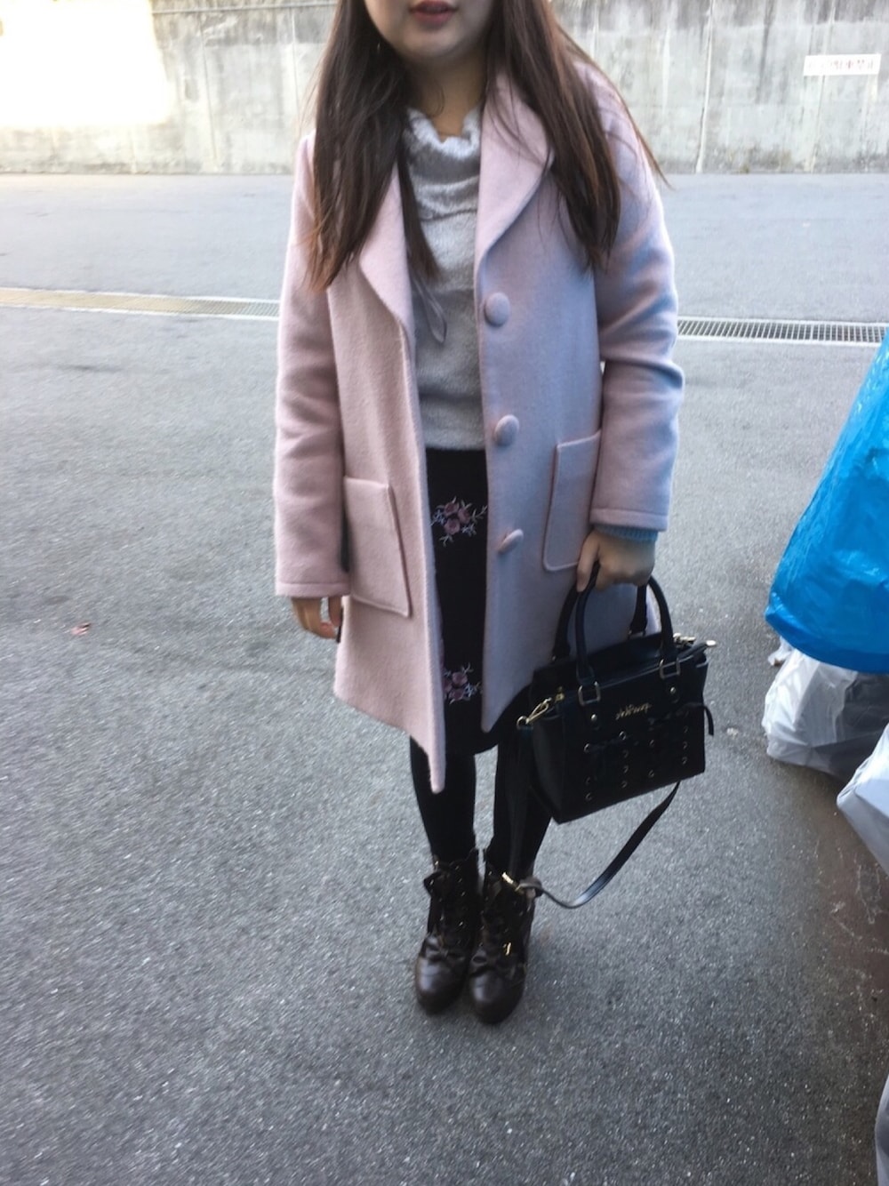 ブラック系のスカート、ブルー系のニット/セーター、ピンク系のジャケット/アウターを着用したレディースの冬コーディネートの1枚目の写真