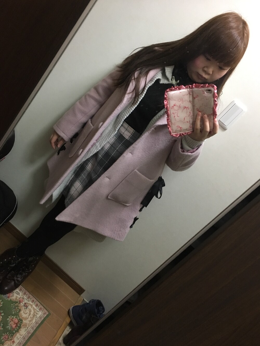 ブラック系のニット/セーター、グレー系のスカート、グレー系のカーディガン/ボレロを着用したレディースの冬コーディネートの1枚目の写真