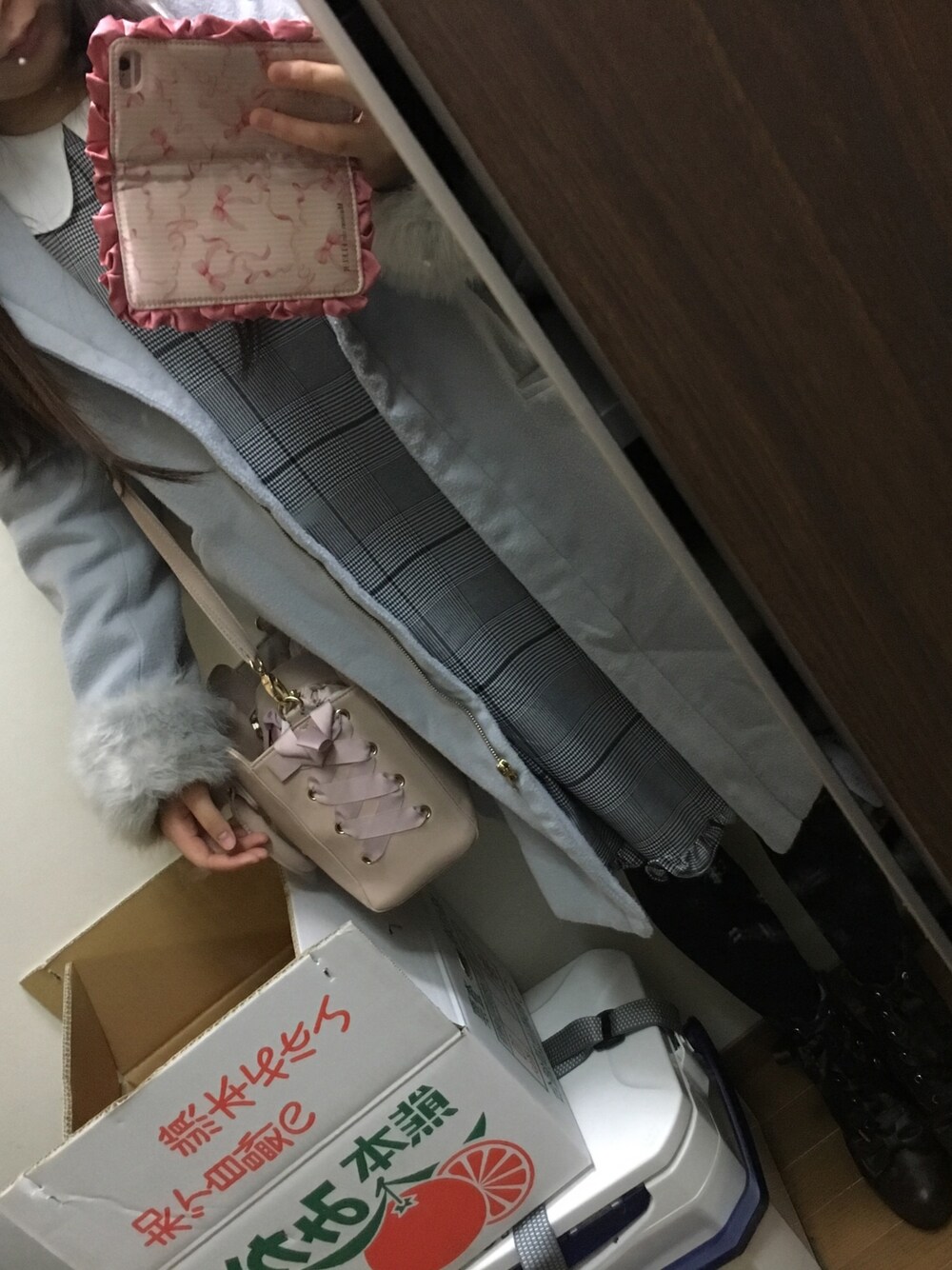 グレー系のワンピース、ブルー系のその他アウター、ピンク系のショルダーバッグを着用したレディースの冬コーディネートの1枚目の写真