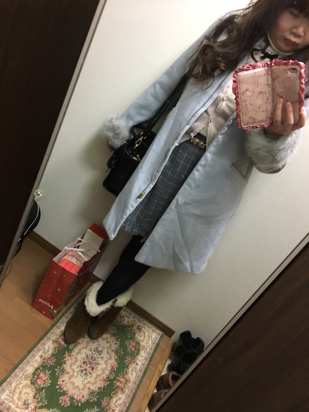 グレー系のスカート、ピンク系のカーディガン/ボレロ、ホワイト系のニット/セーターを着用したレディースの冬コーディネートの1枚目の写真