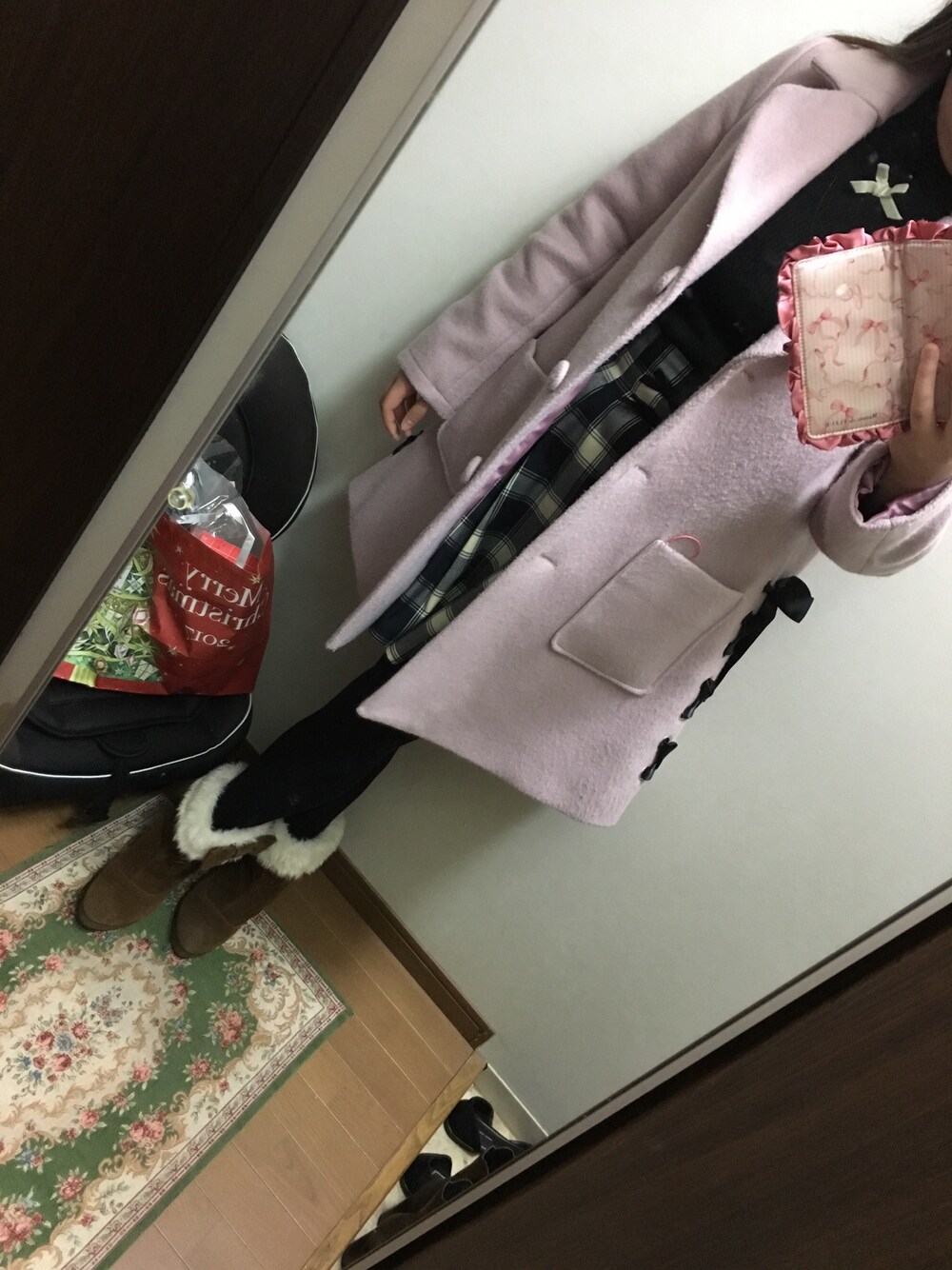 グレー系のスカート、ブラック系のニット/セーター、ピンク系のジャケット/アウターを着用したレディースの冬コーディネートの1枚目の写真