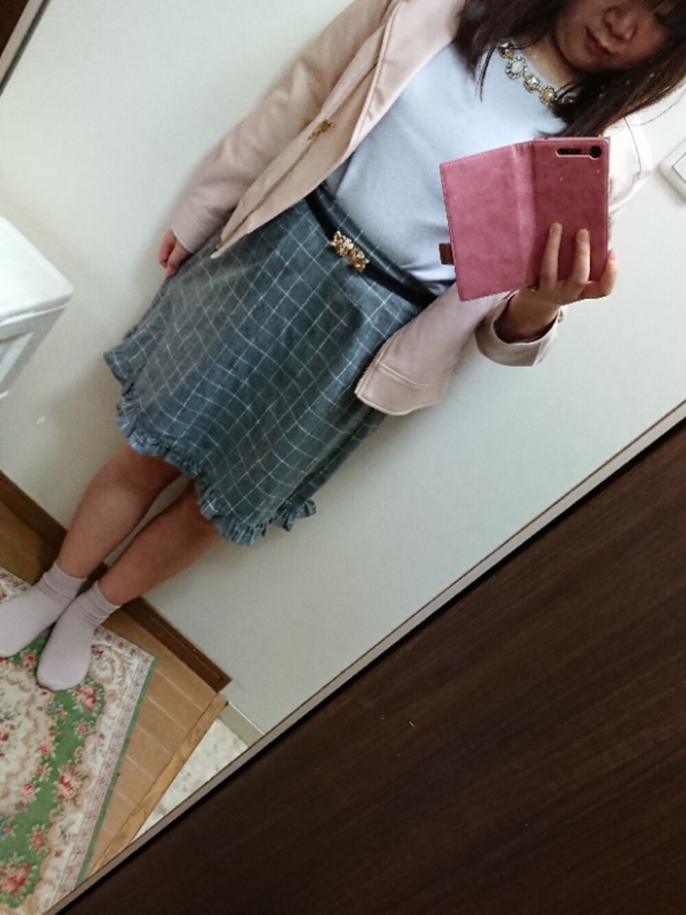 グレー系のニット/セーター、ピンク系のライダースジャケット、グレー系のスカートを着用したレディースの秋コーディネートの1枚目の写真