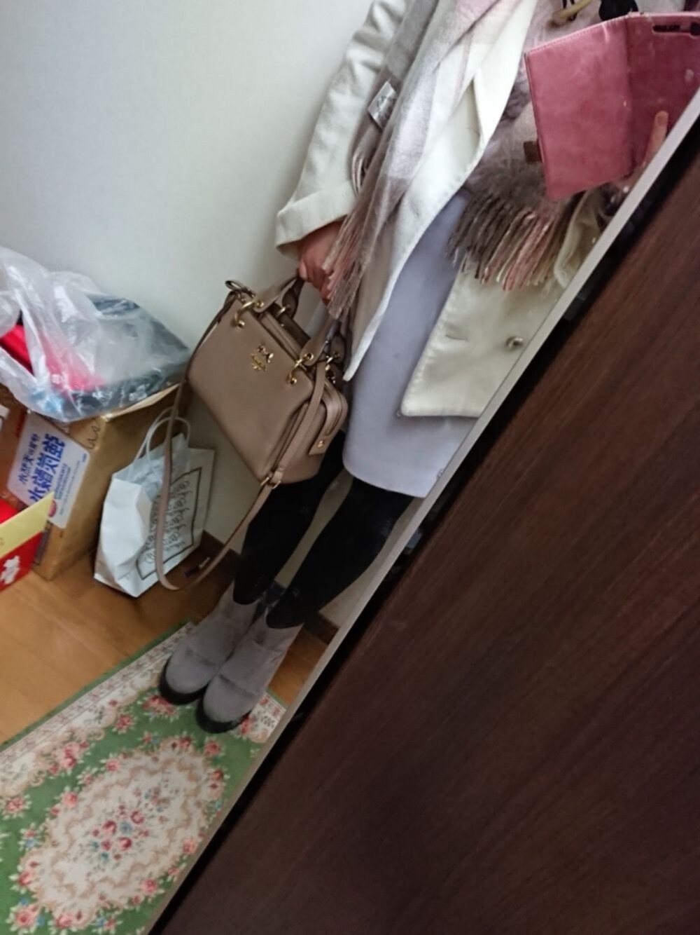 ピンク系のニット/セーター、ブルー系のスカート、ホワイト系のピーコートを着用したレディースの冬コーディネートの1枚目の写真