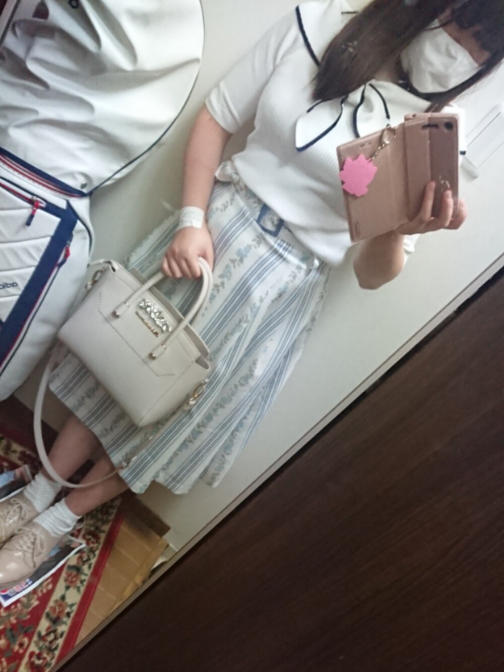 パープル系のスカート、ホワイト系のニット/セーター、グレー系のトートバッグを着用したレディースの夏コーディネートの1枚目の写真