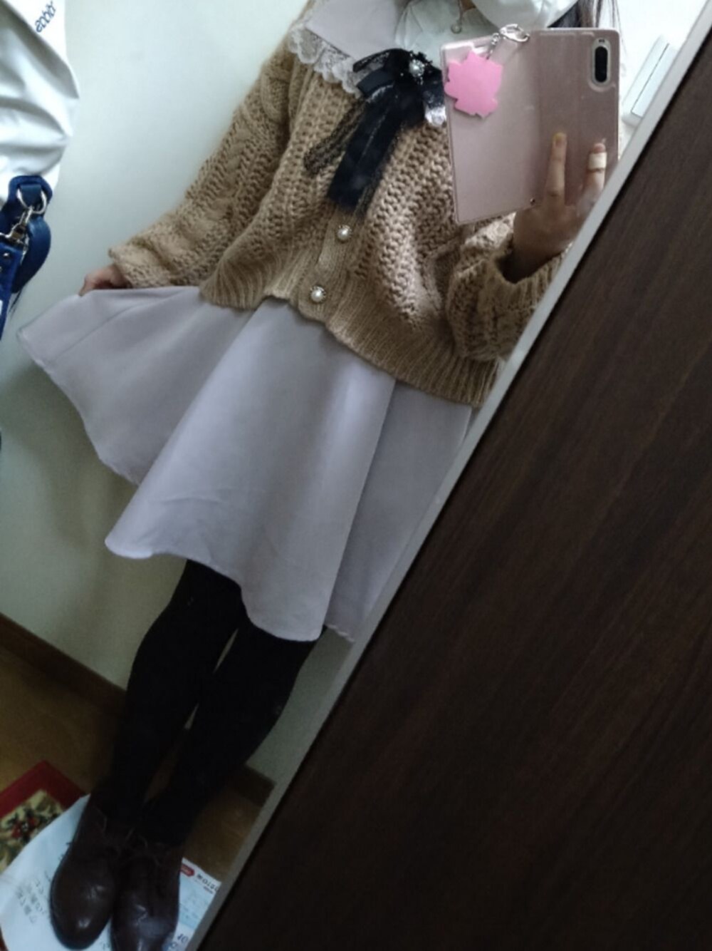 ピンク系のワンピース、ベージュ系のカーディガン/ボレロ、ホワイト系のシャツ/ブラウスを着用したレディースの冬コーディネートの1枚目の写真