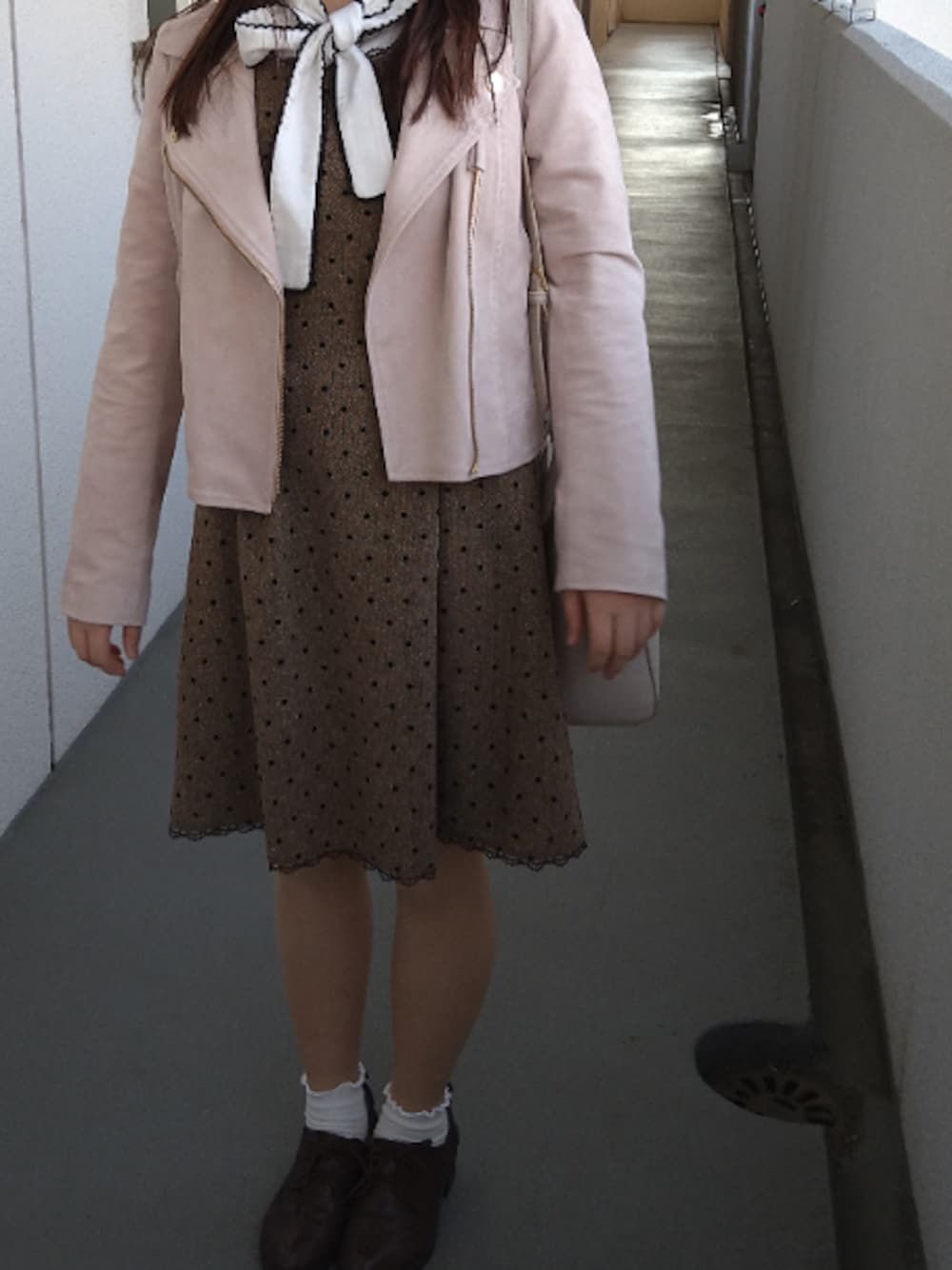 ブラウン系のワンピース、ホワイト系のシャツ/ブラウス、ピンク系のライダースジャケットを着用したレディースの冬コーディネートの1枚目の写真