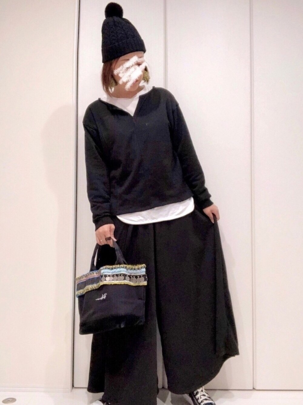 ブラック系のスウェット、ホワイト系のTシャツ/カットソー、ブラック系のトートバッグを着用したレディースの冬コーディネートの1枚目の写真