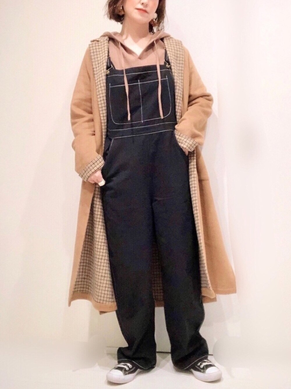 ベージュ系のジャケット/アウター、ブラウン系のニット/セーター、ブラック系のサロペット/オーバーオールを着用したレディースの冬コーディネートの1枚目の写真