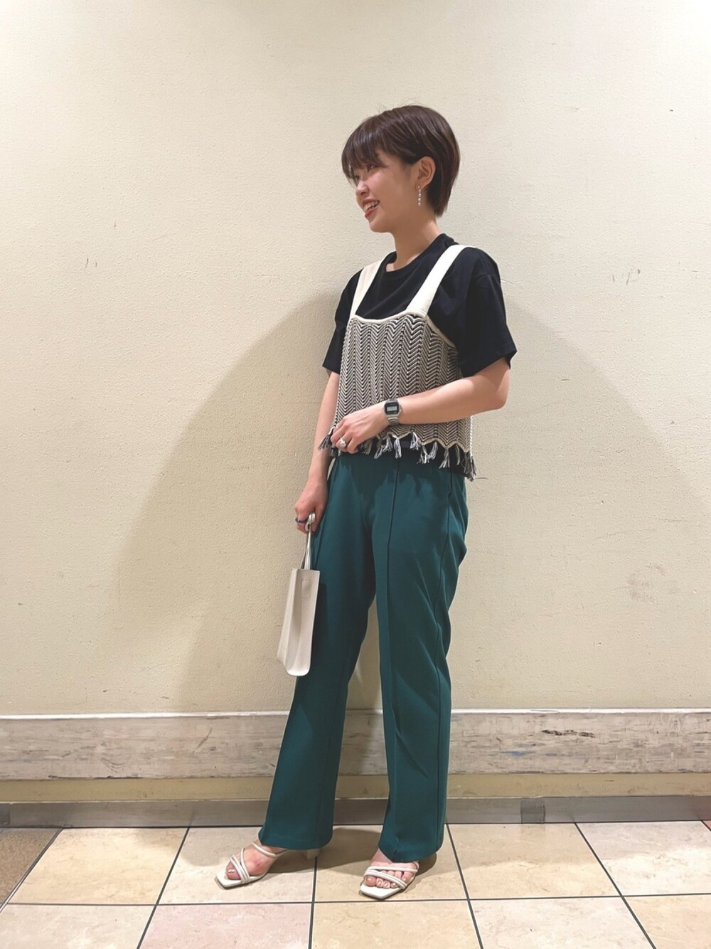 グリーン系のその他パンツ、ホワイト系のショルダーバッグ、ゴールド系のサンダルを着用したレディースの春コーディネートの1枚目の写真