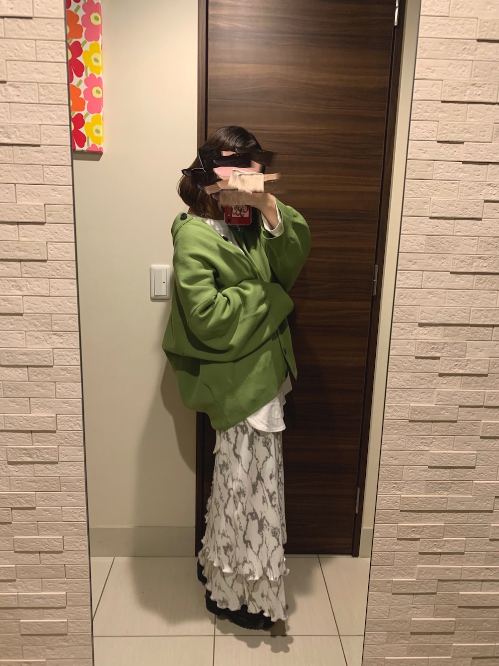 グリーン系のカーディガン/ボレロ、ホワイト系のTシャツ/カットソー、ホワイト系のスカートを着用したレディースの冬コーディネートの1枚目の写真