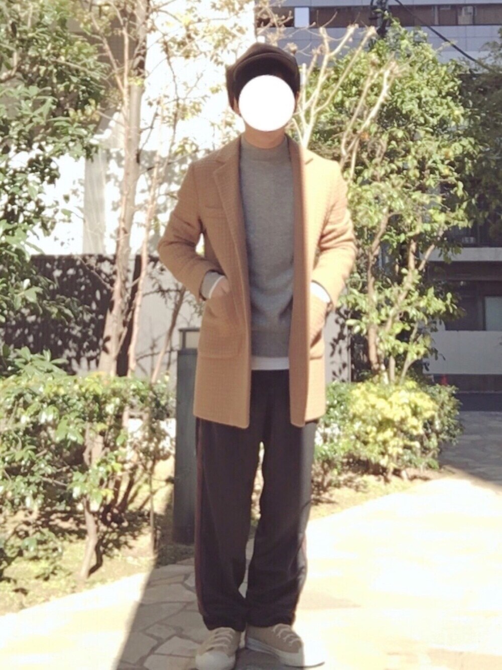 イエロー系のチェスターコート、グレー系のニット/セーター、ブラック系のその他パンツを着用したメンズの冬コーディネートの1枚目の写真
