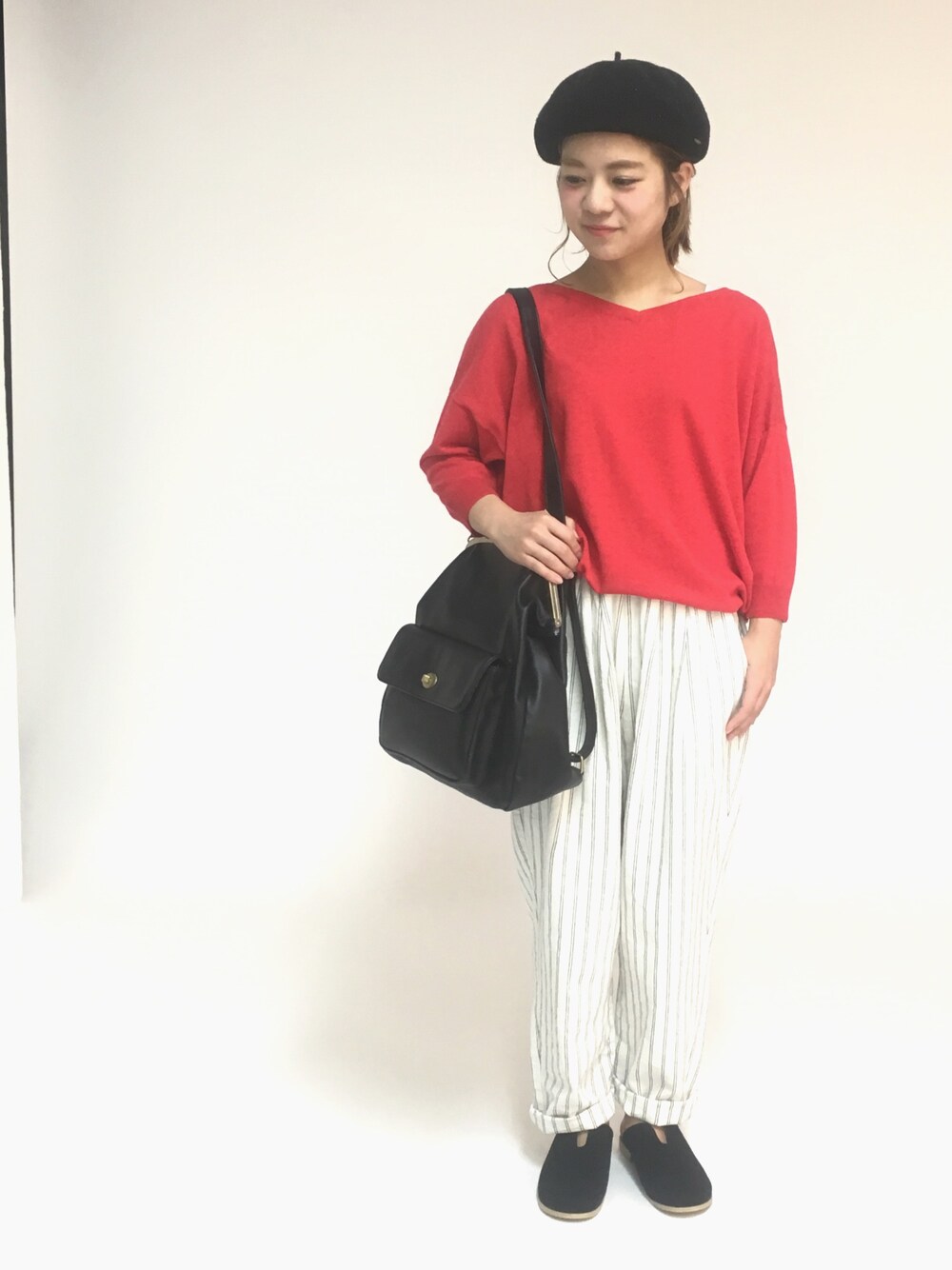 レッド系のニット/セーター、その他のその他パンツ、ブラック系のバックパック/リュックを着用したレディースの春コーディネートの1枚目の写真