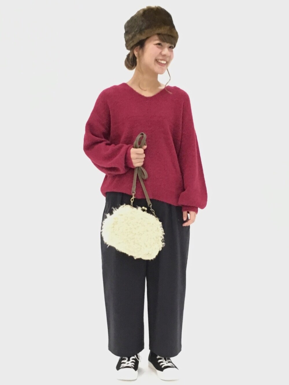 レッド系のニット/セーター、ブルー系のその他パンツ、ベージュ系のバッグを着用したレディースの秋コーディネートの1枚目の写真