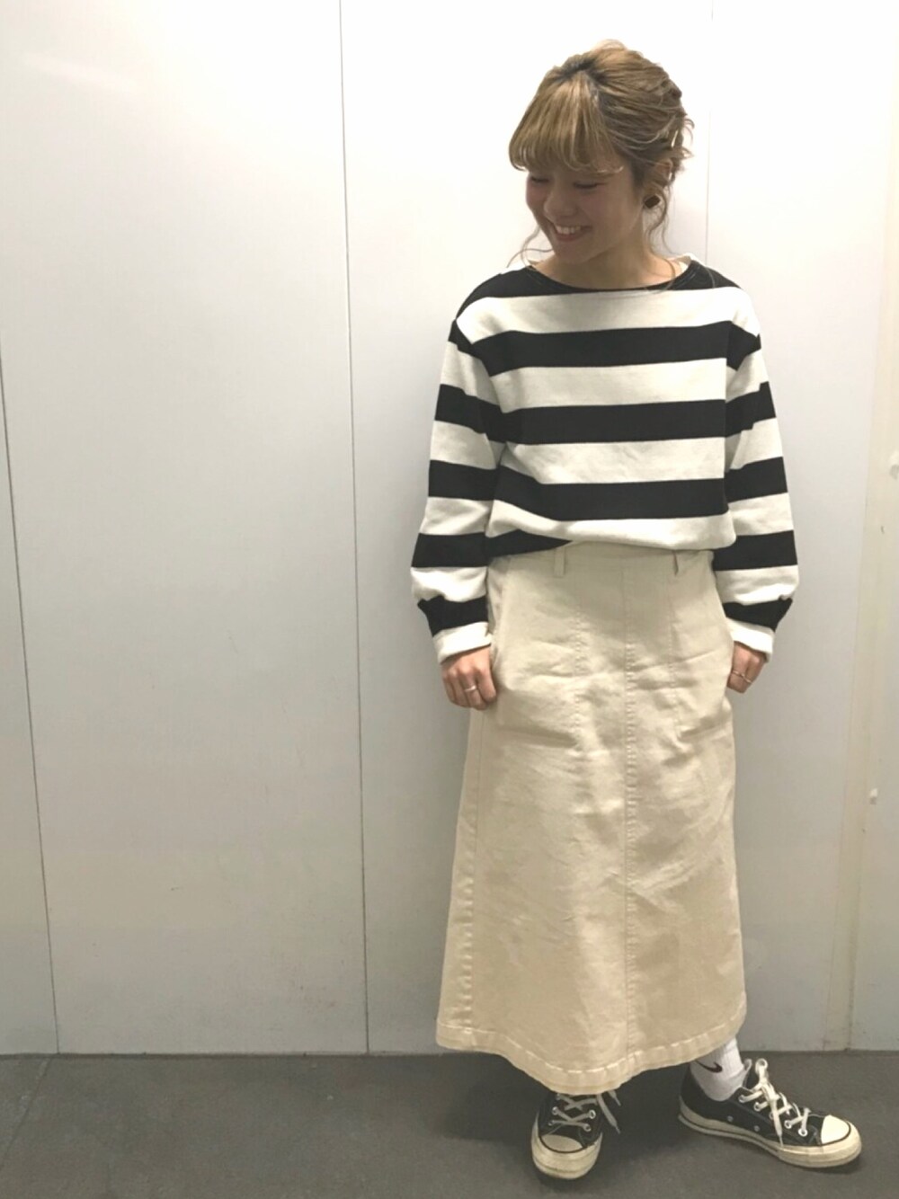 ブラック系のTシャツ/カットソー、ベージュ系のスカートを着用したレディースの春コーディネートの1枚目の写真