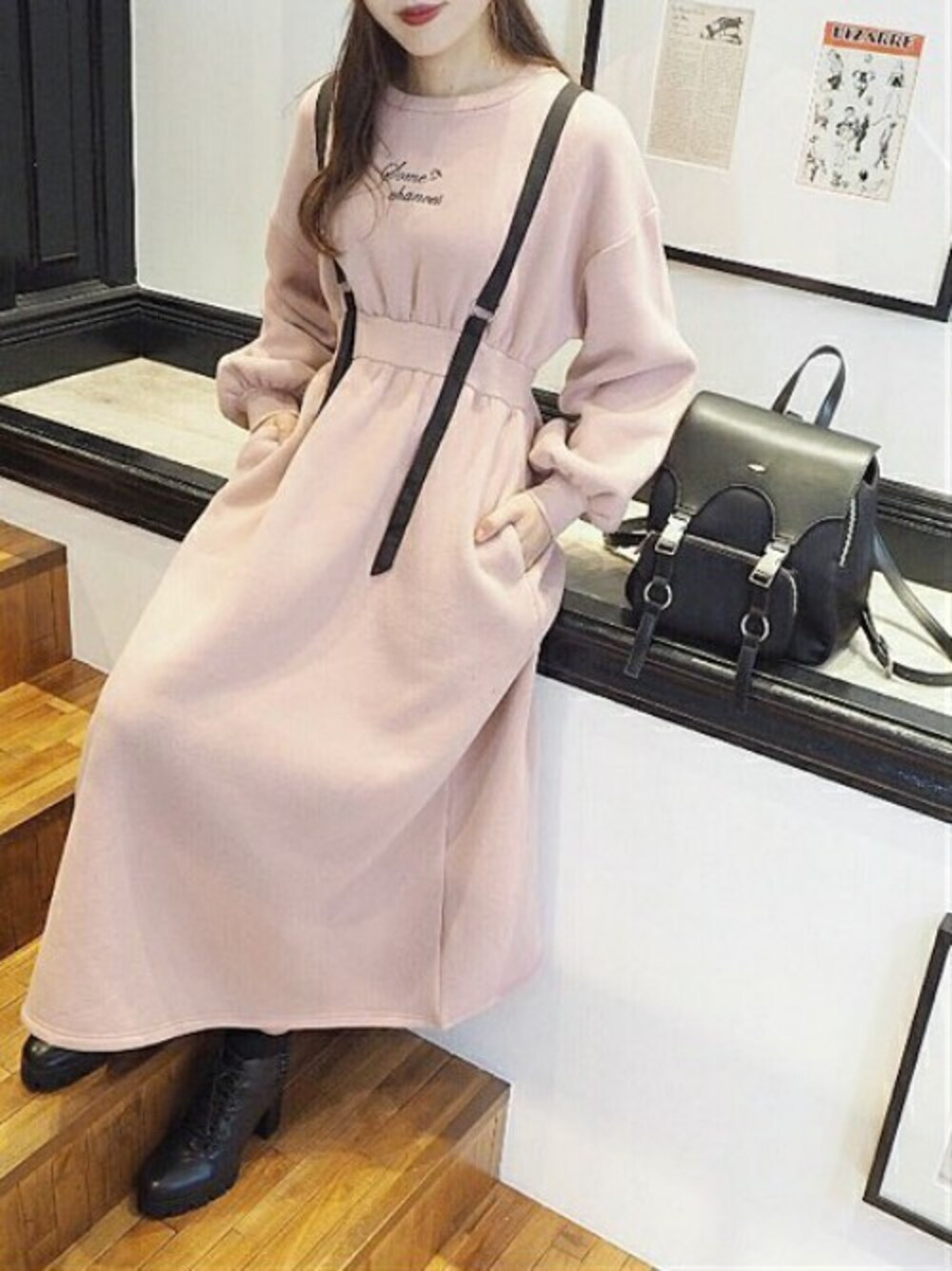 ピンク系のワンピース、ブラック系のバックパック/リュック、ブラック系のブーツを着用したレディースの秋コーディネートの1枚目の写真