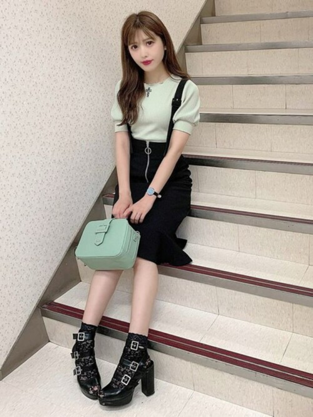 グリーン系のショルダーバッグ、ブラック系のジャンパースカート、グリーン系のTシャツ/カットソーを着用したレディースの夏コーディネートの1枚目の写真