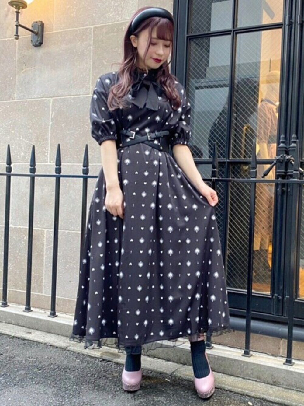 パープル系のワンピース、ピンク系のパンプス、ブラック系のベルトを着用したレディースの夏コーディネートの1枚目の写真