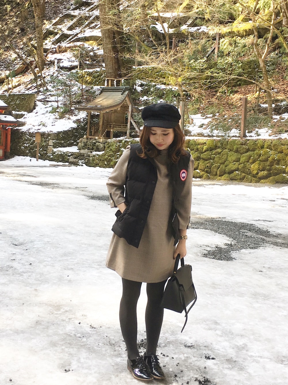 ブラック系のダウンベストを着用したレディースの冬コーディネートの1枚目の写真