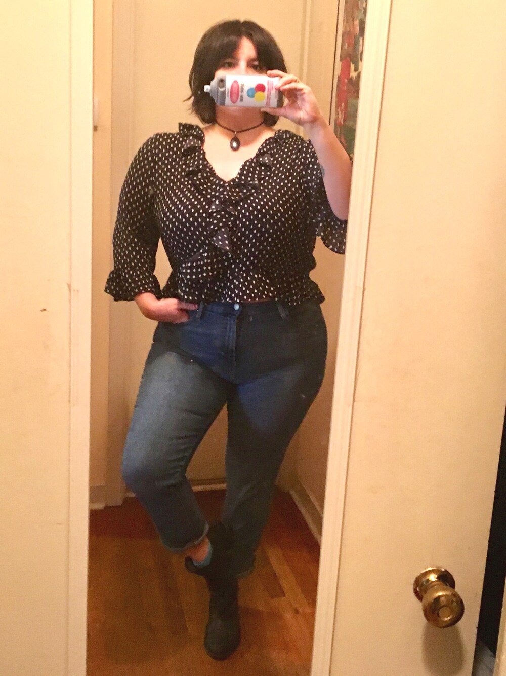 ブルー系のデニムパンツ、ブラック系のトップス、ブラック系のブーティを着用したレディースの秋コーディネートの1枚目の写真