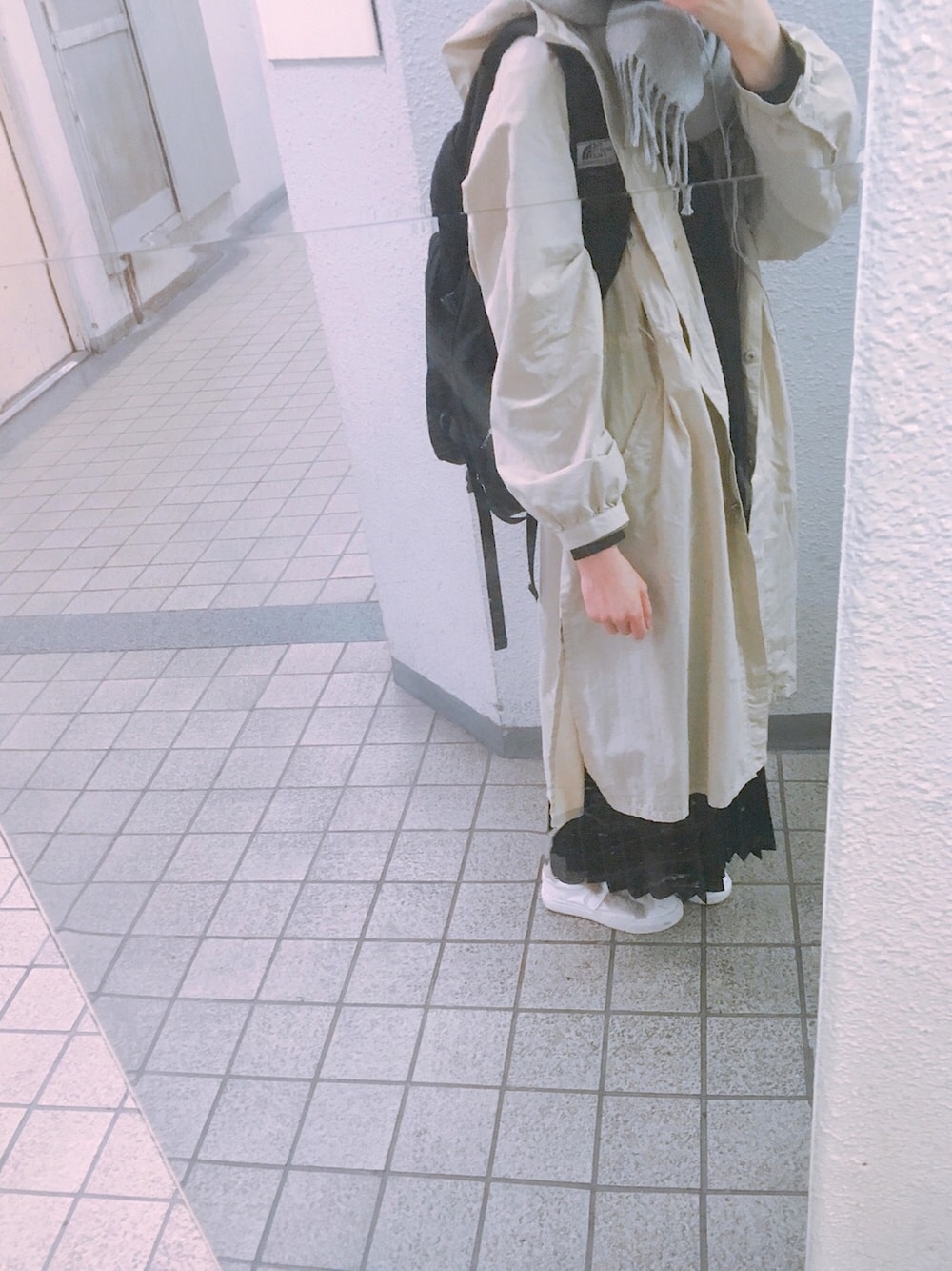 ブラック系のバックパック/リュック、ベージュ系のその他アウター、ホワイト系のスニーカーを着用したレディースの秋コーディネートの1枚目の写真