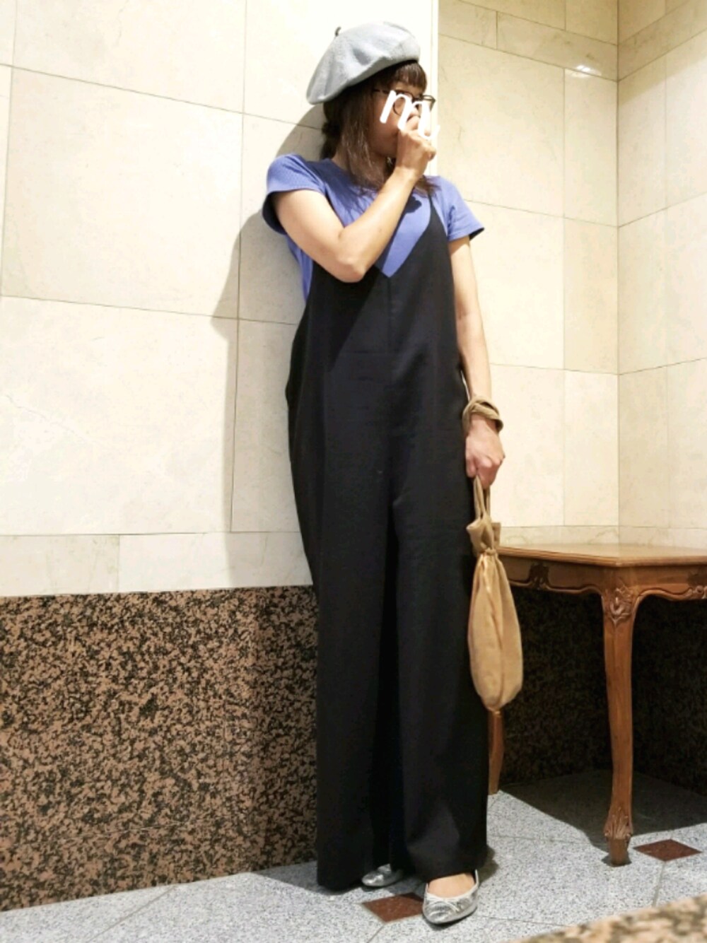 ブルー系のTシャツ/カットソー、ブラック系のサロペット/オーバーオール、ブラウン系のバッグを着用したレディースの秋コーディネートの1枚目の写真