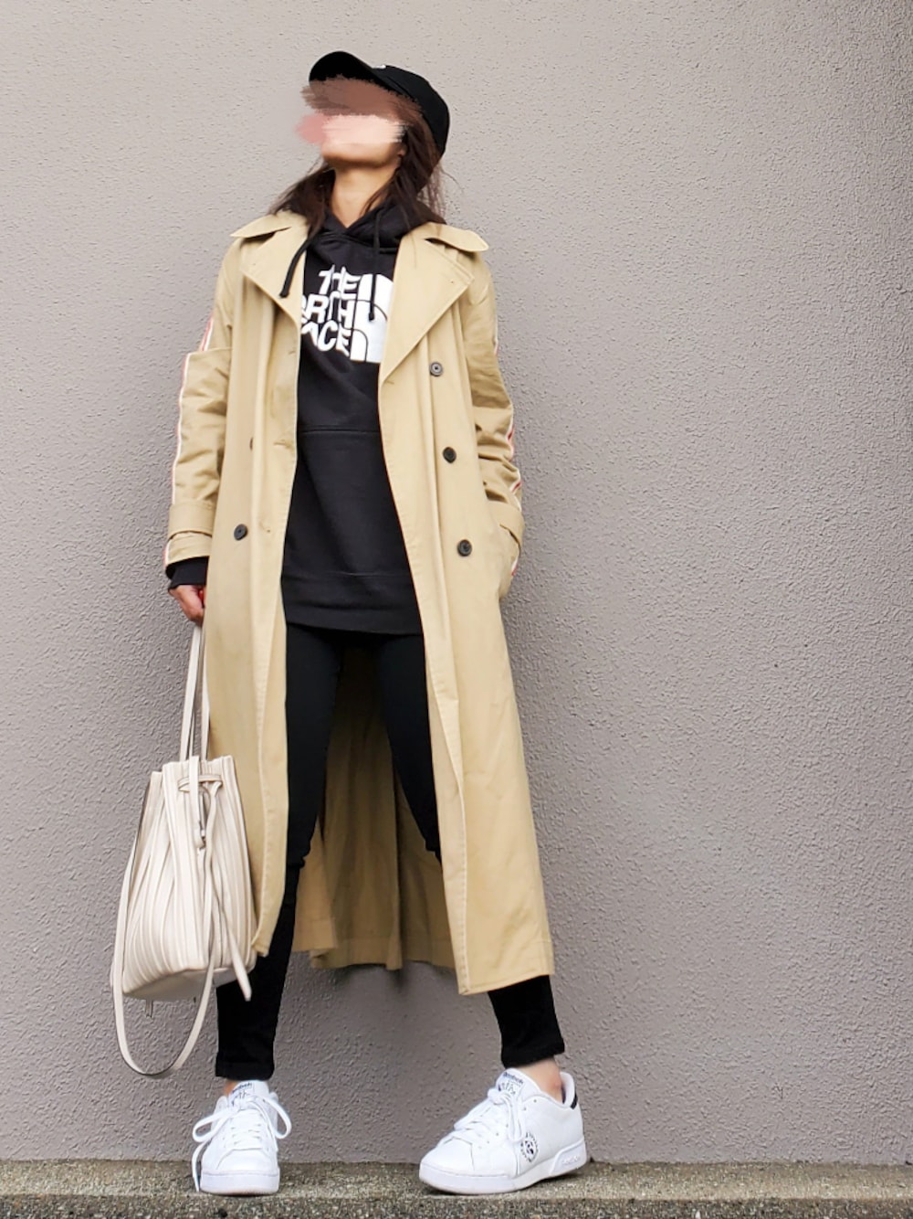 ベージュ系のトレンチコート、ブラック系のパーカー、ブラック系のその他パンツを着用したレディースの春コーディネートの1枚目の写真