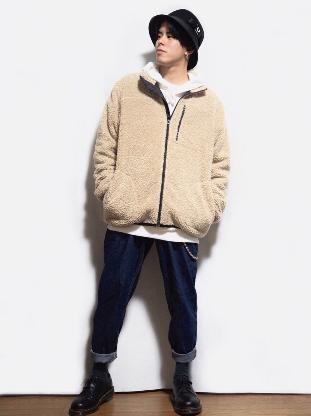 ブルー系のデニムパンツ、ベージュ系のブルゾン、ホワイト系のパーカーを着用したメンズの冬コーディネートの1枚目の写真