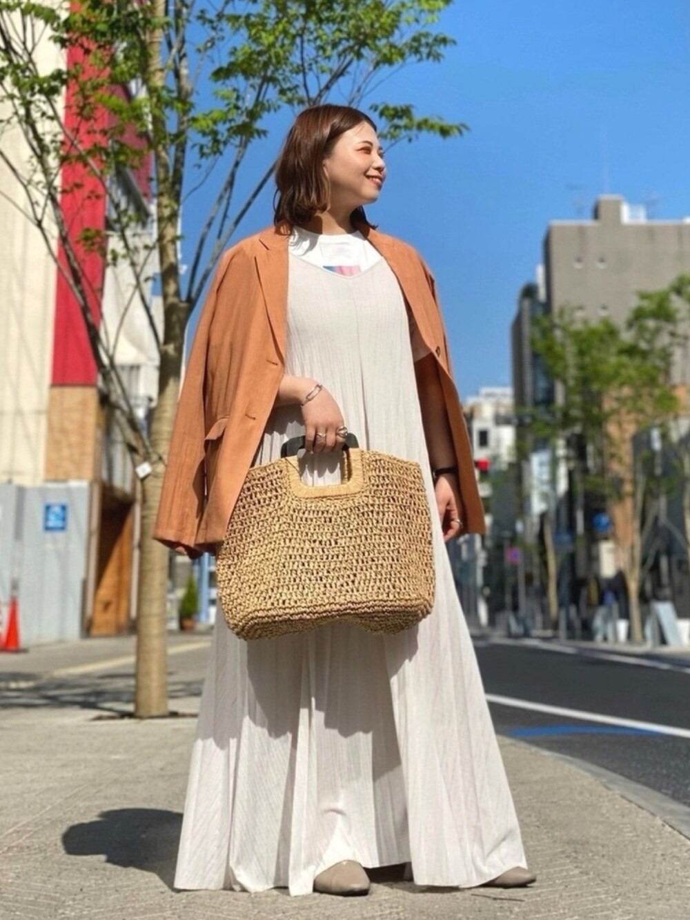 オレンジ系のテーラードジャケット、ホワイト系のTシャツ/カットソー、ホワイト系のワンピースを着用したレディースの春コーディネートの1枚目の写真