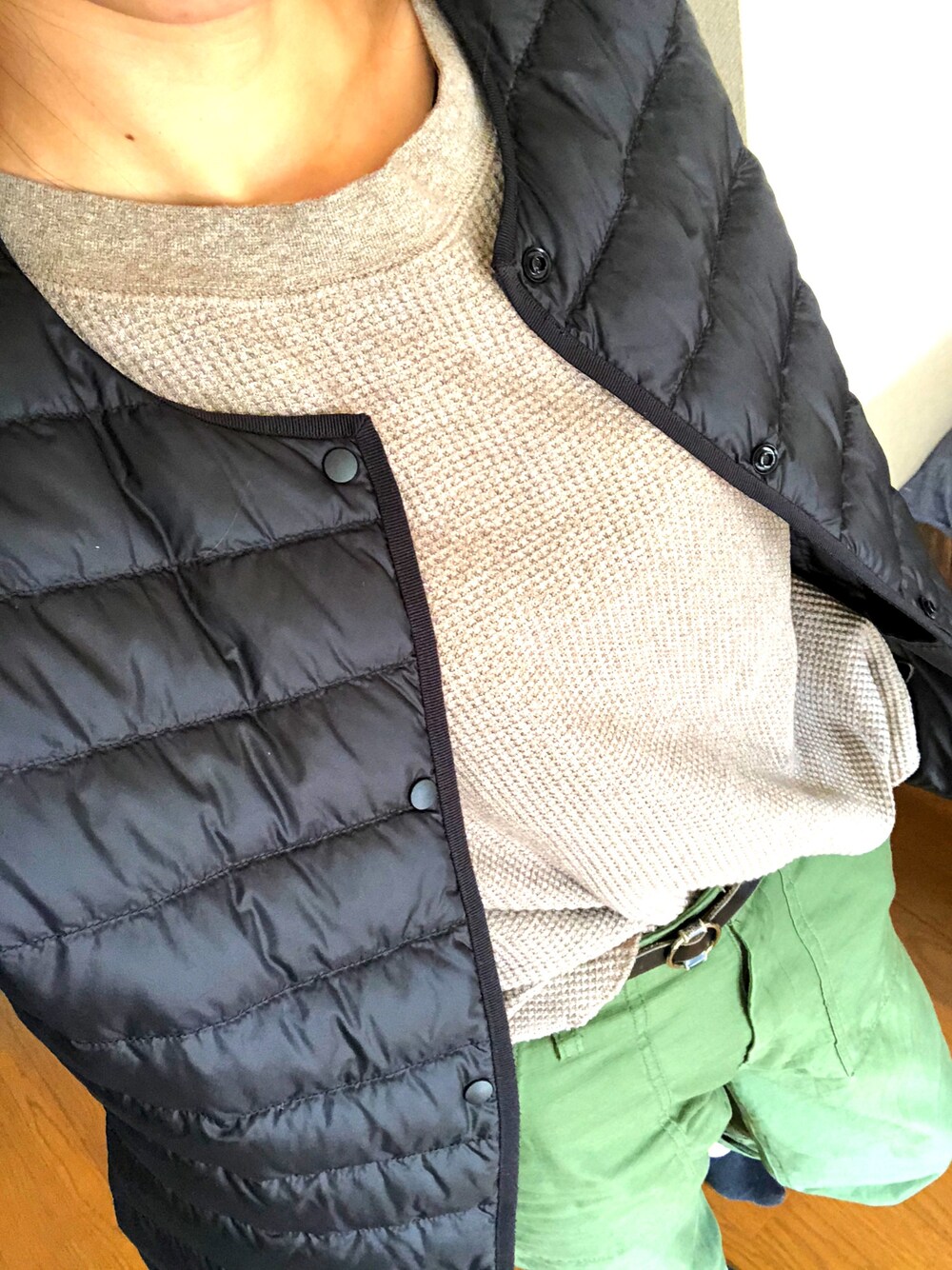ブラウン系のTシャツ/カットソー、ブラック系のダウンジャケット/コート、グリーン系のその他パンツを着用したレディースの秋コーディネートの1枚目の写真
