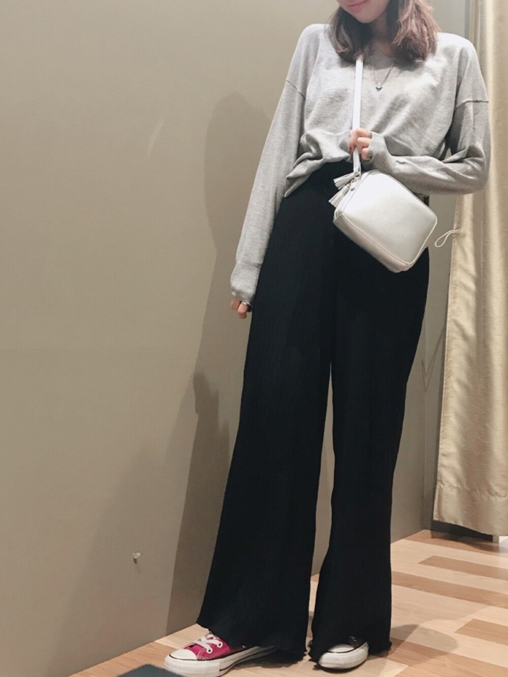 グレー系のニット/セーター、ブラック系のその他パンツ、シルバー系のハンドバッグを着用したレディースの秋コーディネートの1枚目の写真