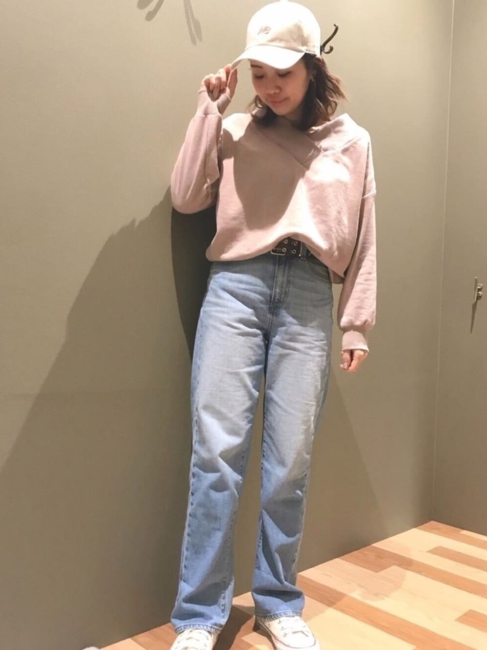 ピンク系のTシャツ/カットソー、ブルー系のデニムパンツ、ホワイト系のキャップを着用したレディースの冬コーディネートの1枚目の写真