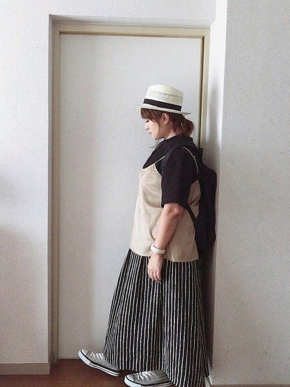 ブラック系のTシャツ/カットソー、ベージュ系のキャミソール、ブラック系のスカートを着用したレディースの秋コーディネートの1枚目の写真