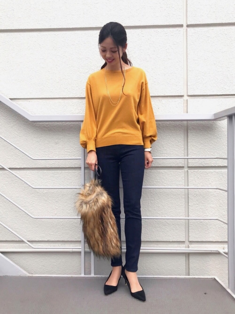 イエロー系のニット/セーター、ブルー系のその他パンツ、ブラック系のパンプスを着用したレディースの秋コーディネートの1枚目の写真