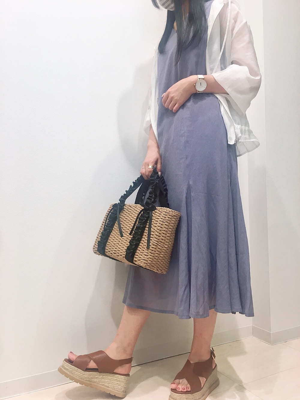 ホワイト系のブルゾン、ブルー系のワンピース、ブラウン系のかごバッグを着用したレディースの夏コーディネートの1枚目の写真