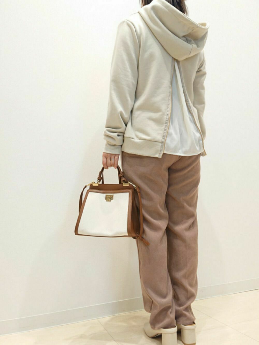 ピンク系のその他パンツ、イエロー系のショルダーバッグ、ベージュ系のパーカーを着用したレディースの秋コーディネートの1枚目の写真