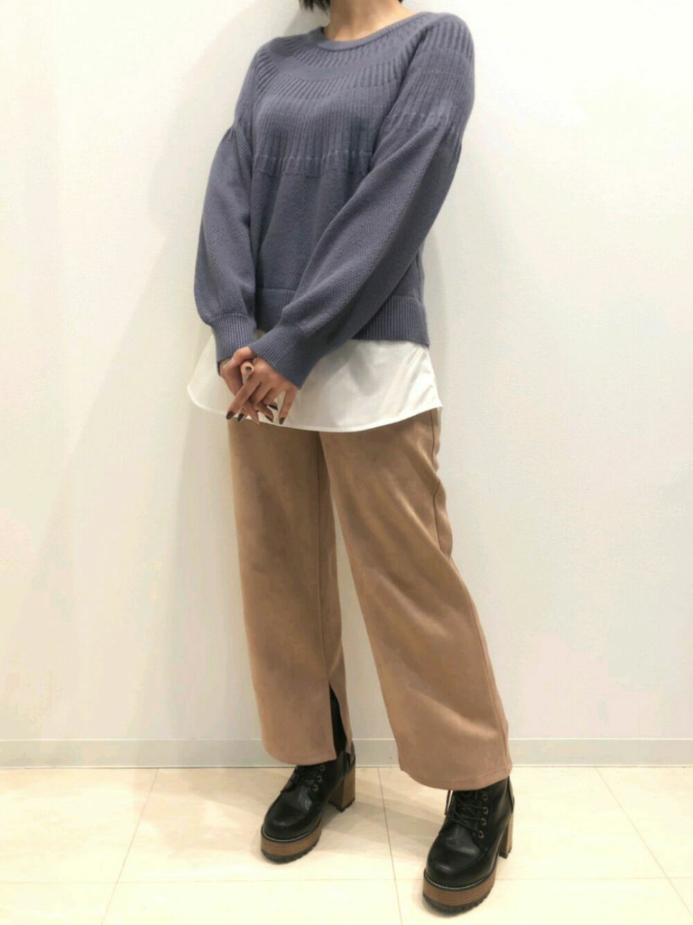 ピンク系のパンツ、ブルー系のニット/セーターを着用したレディースの冬コーディネートの1枚目の写真