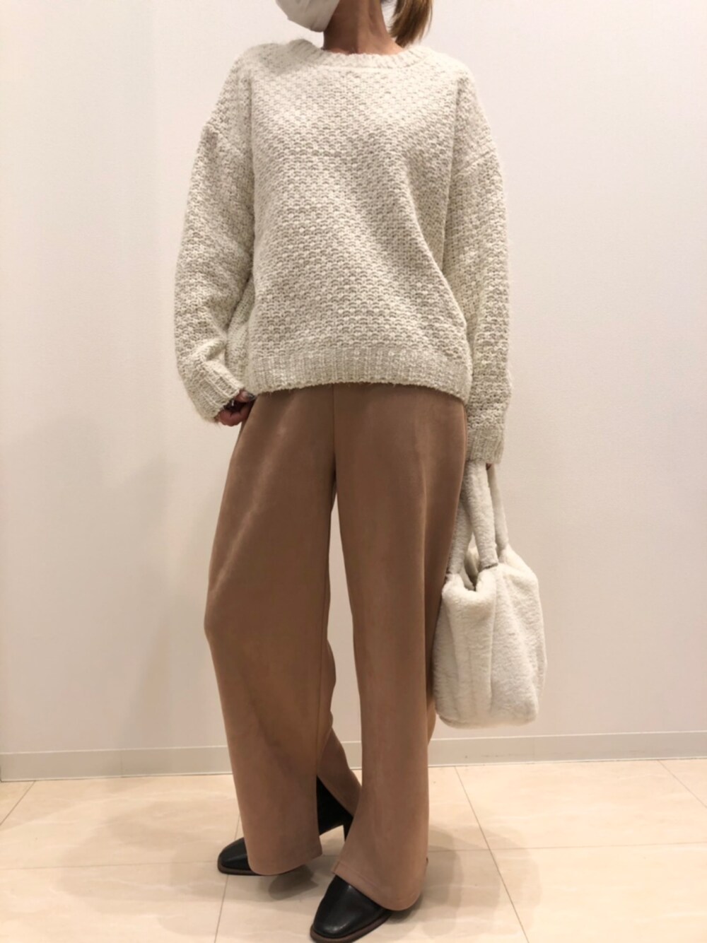 オレンジ系のその他パンツ、ホワイト系のニット/セーターを着用したレディースの冬コーディネートの1枚目の写真