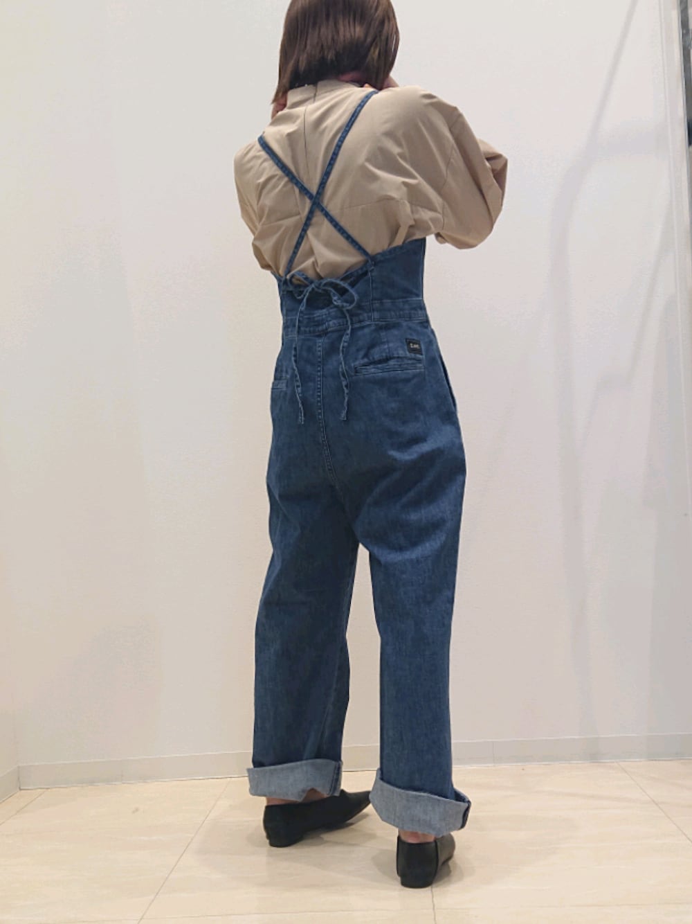 ブルー系のつなぎ/オールインワン、ベージュ系のシャツ/ブラウス、ブラック系のシューズを着用したレディースの春コーディネートの1枚目の写真