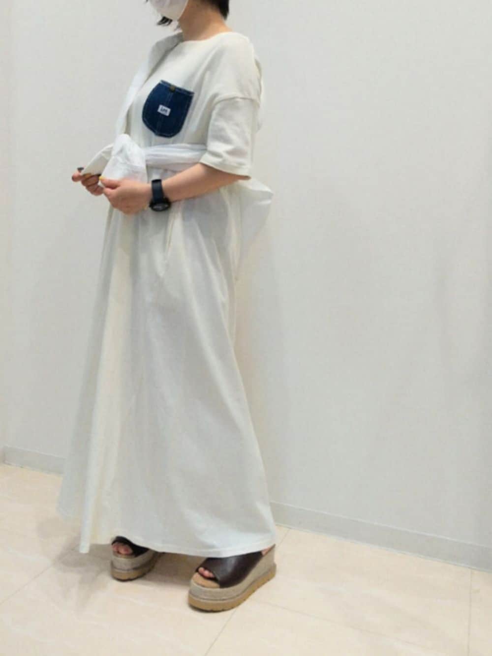 ベージュ系のワンピース、ホワイト系のシャツ/ブラウス、ブラウン系のサンダルを着用したレディースの春コーディネートの1枚目の写真