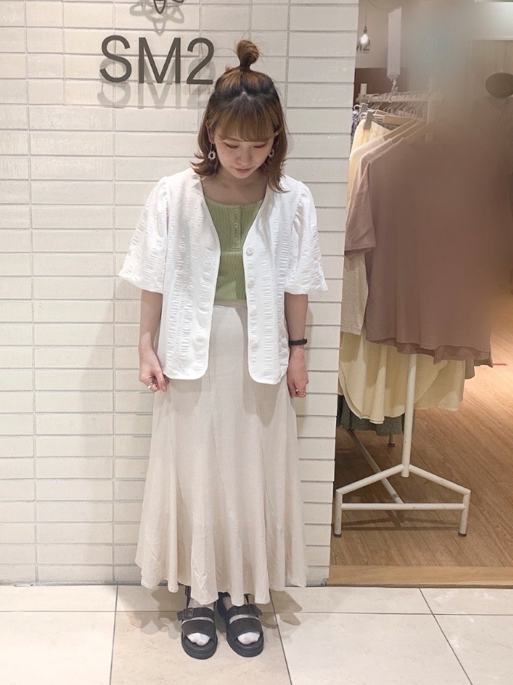 ホワイト系のシャツ/ブラウス、グリーン系のタンクトップ、ホワイト系のスカートを着用したレディースの春コーディネートの1枚目の写真