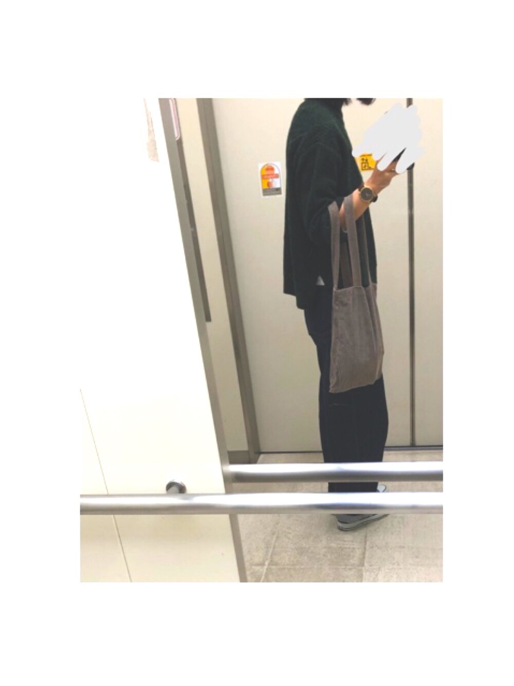 ブラック系のデニムパンツ、グレー系のスニーカーを着用したレディースの秋コーディネートの1枚目の写真