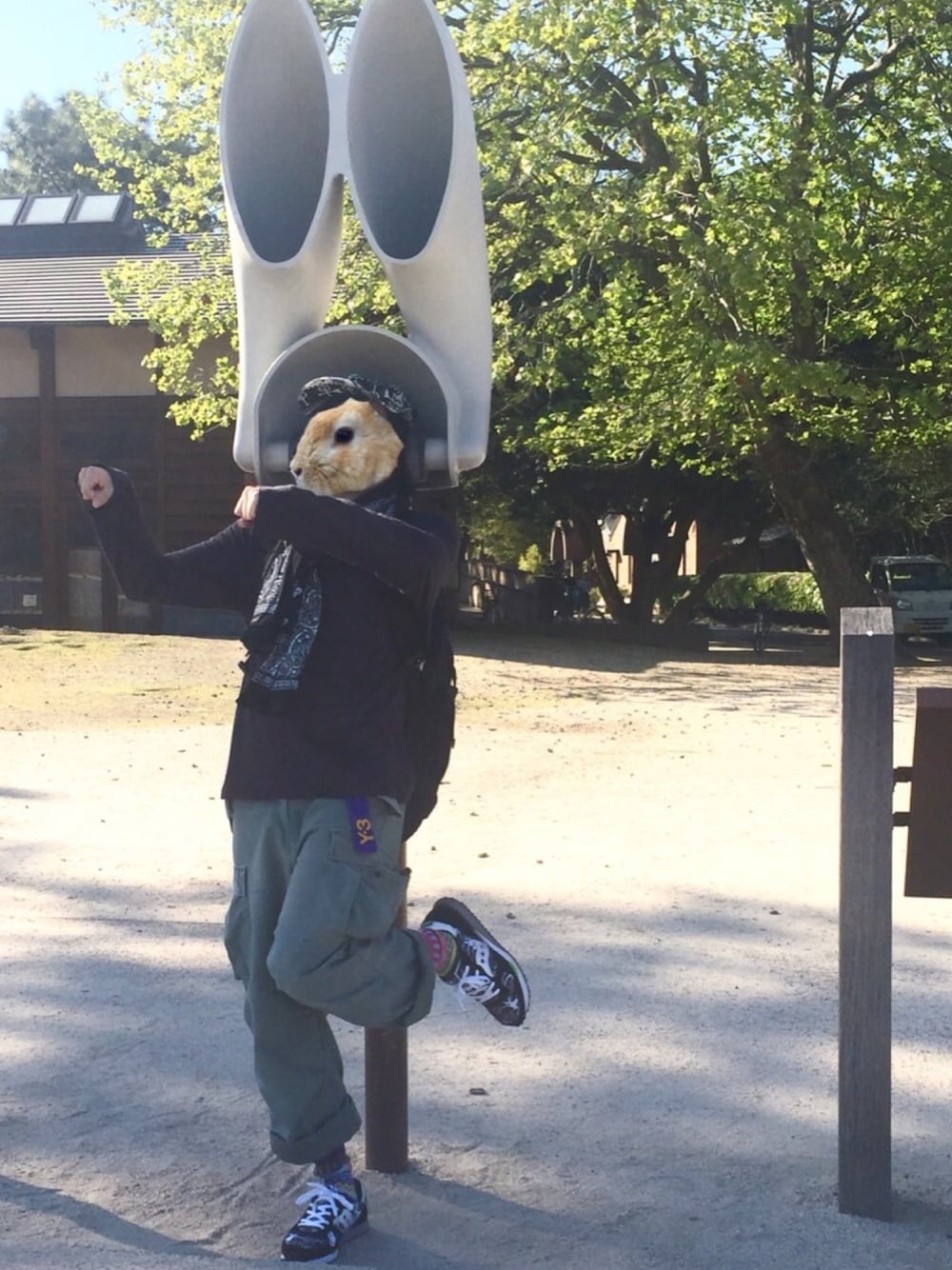 ブラック系のバックパック/リュック、グレー系のTシャツ/カットソー、グリーン系のカーゴパンツを着用したメンズの春コーディネートの1枚目の写真